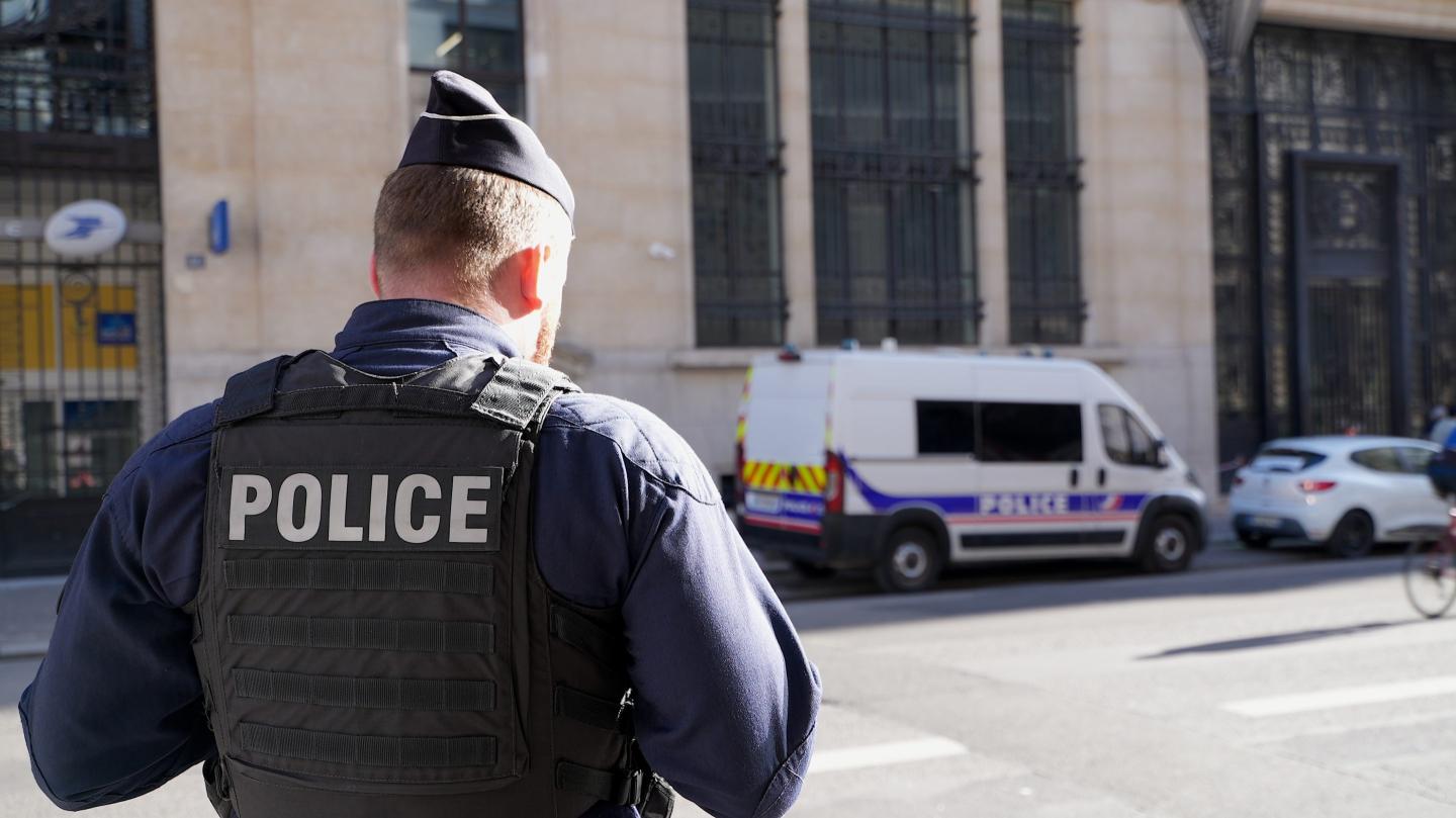 Police stand outside the Bank of America building in Paris, Saturday, March 28, 2026. 
