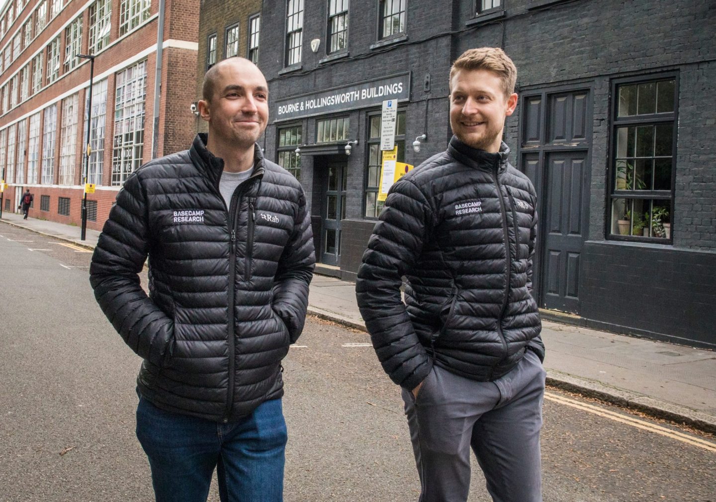 Basecamp Research cofounders Oliver Vince and Glen Gowers photographed walking down a street wearing puffer jackets.