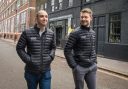 Basecamp Research cofounders Oliver Vince and Glen Gowers photographed walking down a street wearing puffer jackets.