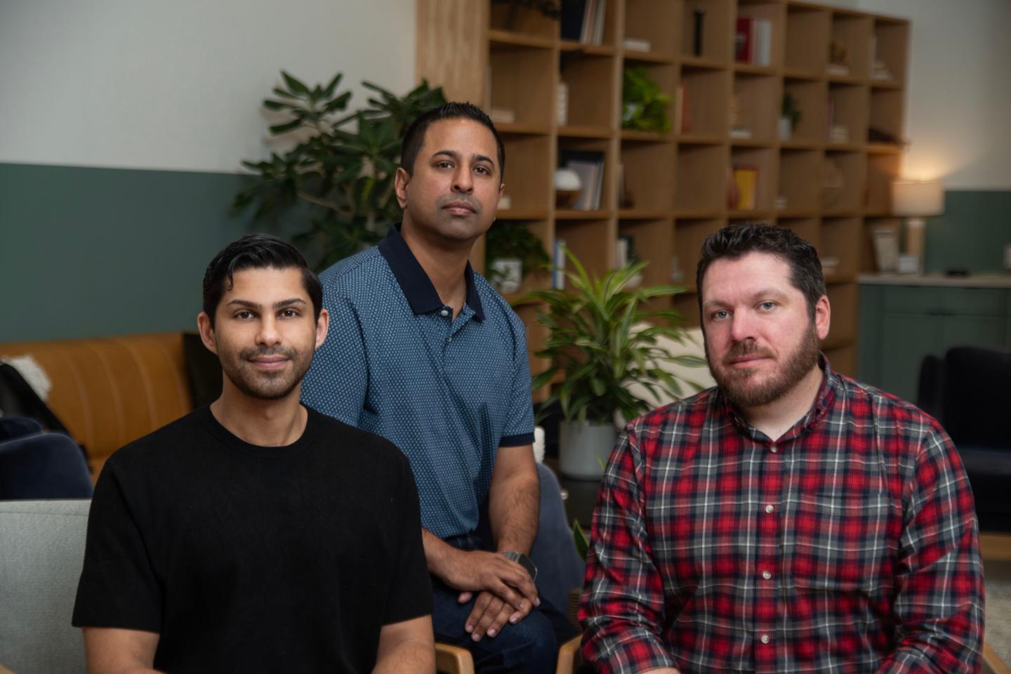 three men pose for camera