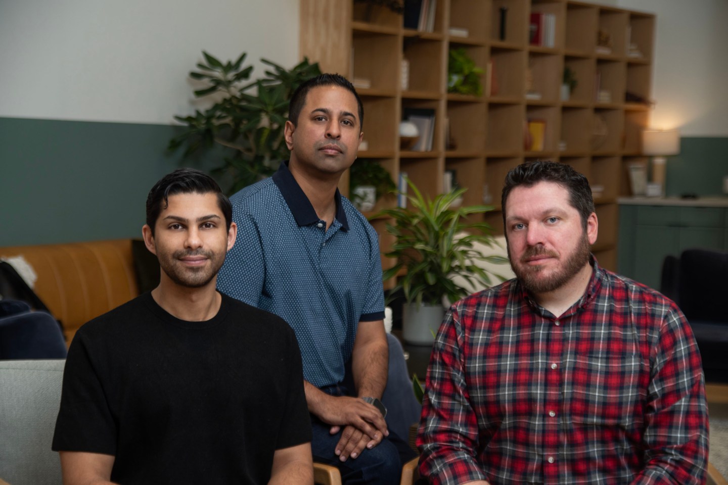 three men pose for camera