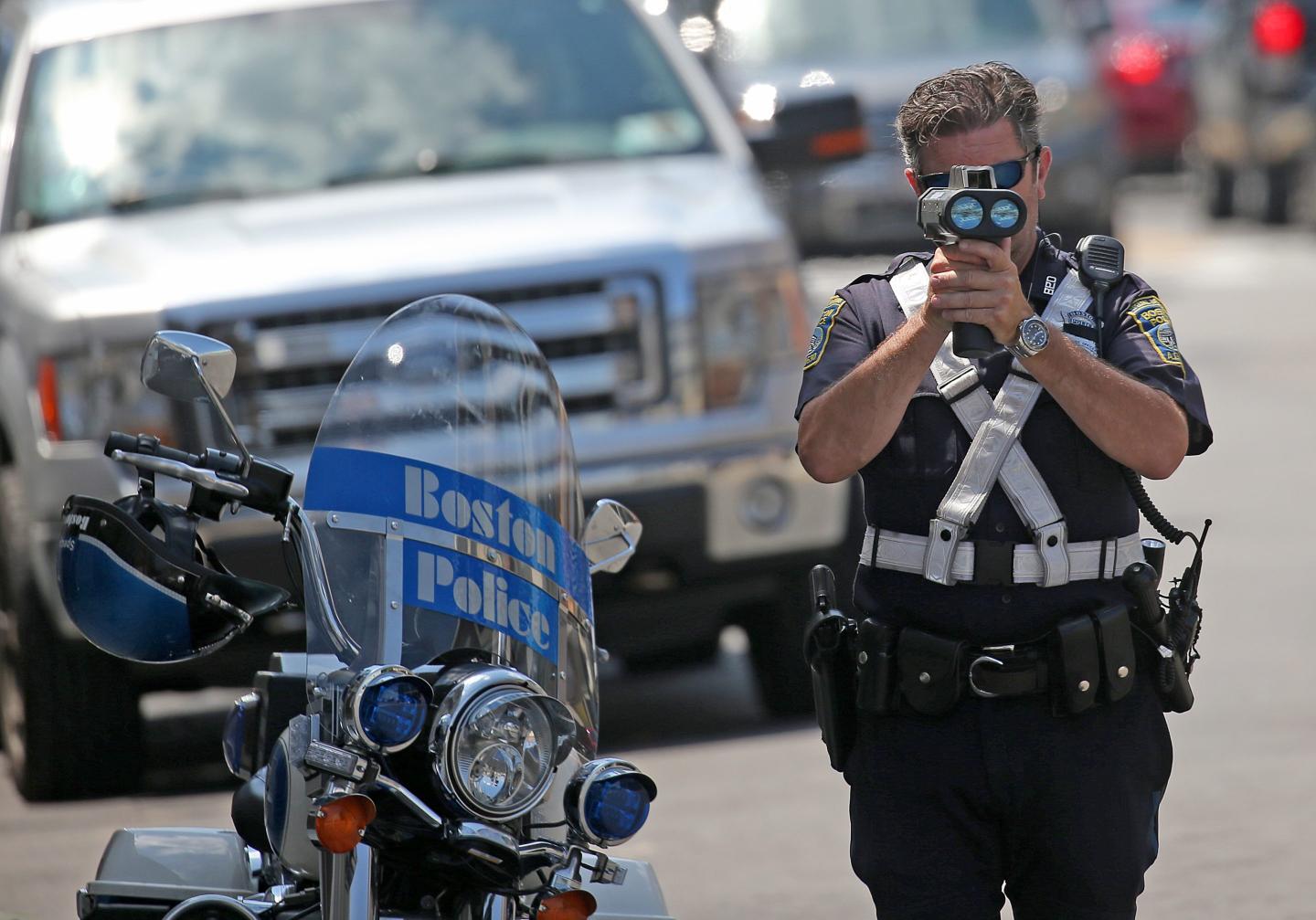 A Boston police officer uses radar to track speeding vehicles