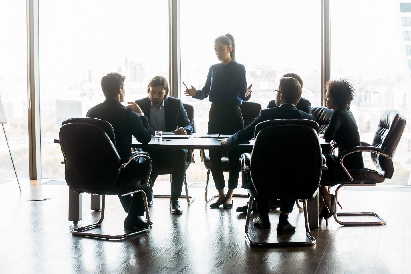 Woman CEO speaks in boardroom at meeting.