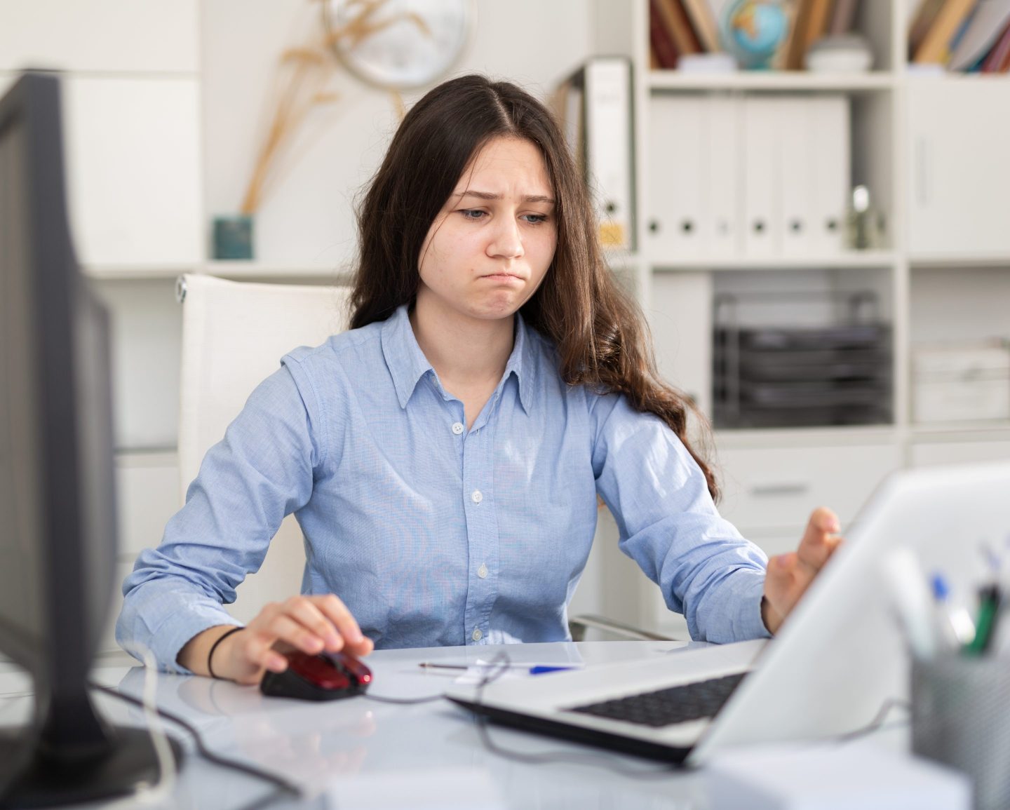 A woman looks frustrated a computer