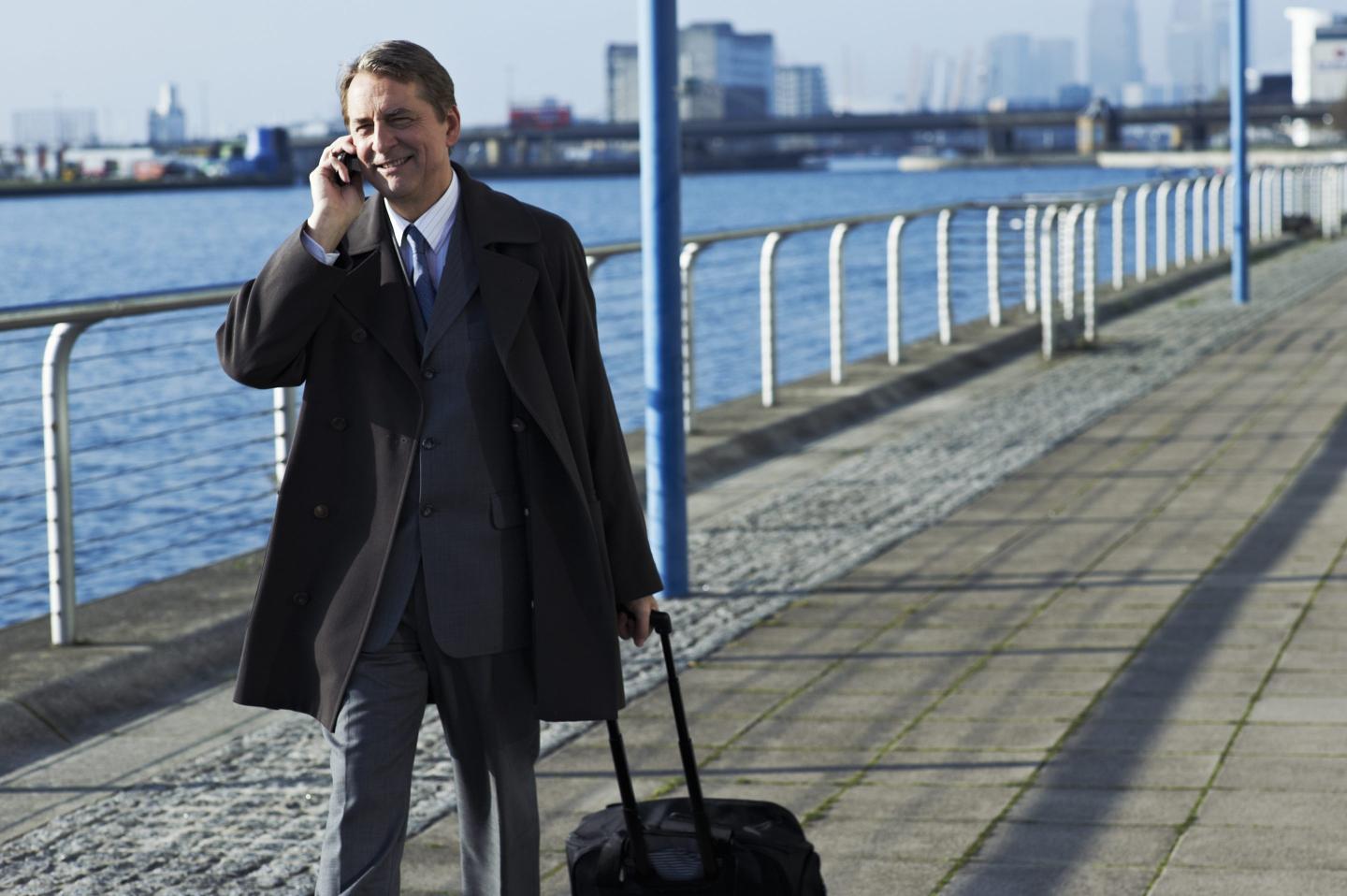 Business man on the phone with luggage