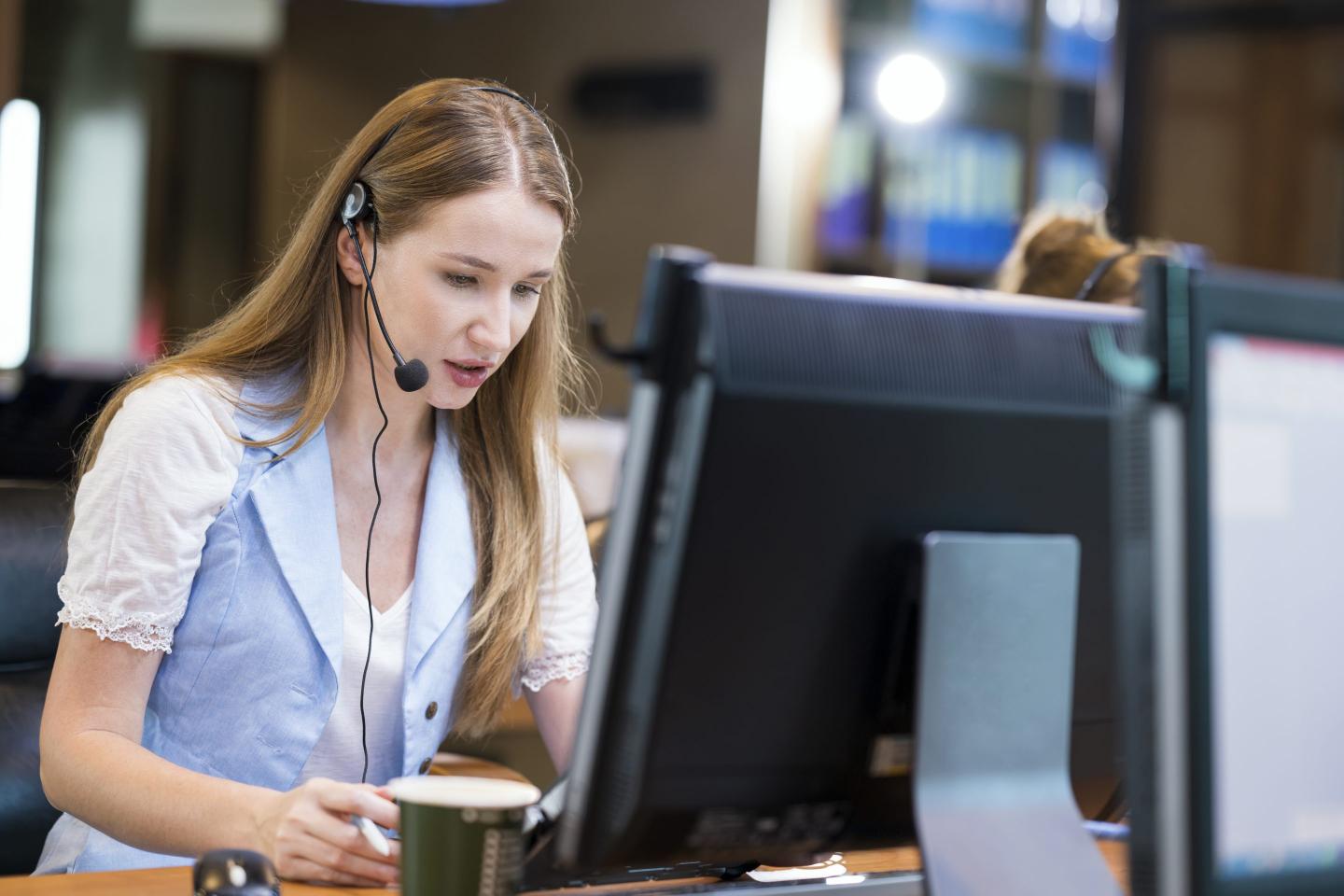 Woman wearing headphones working at a computer