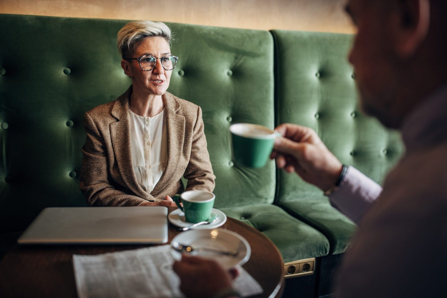 Mature businesswoman talking to a mature man in cafe, he is on a job interview.