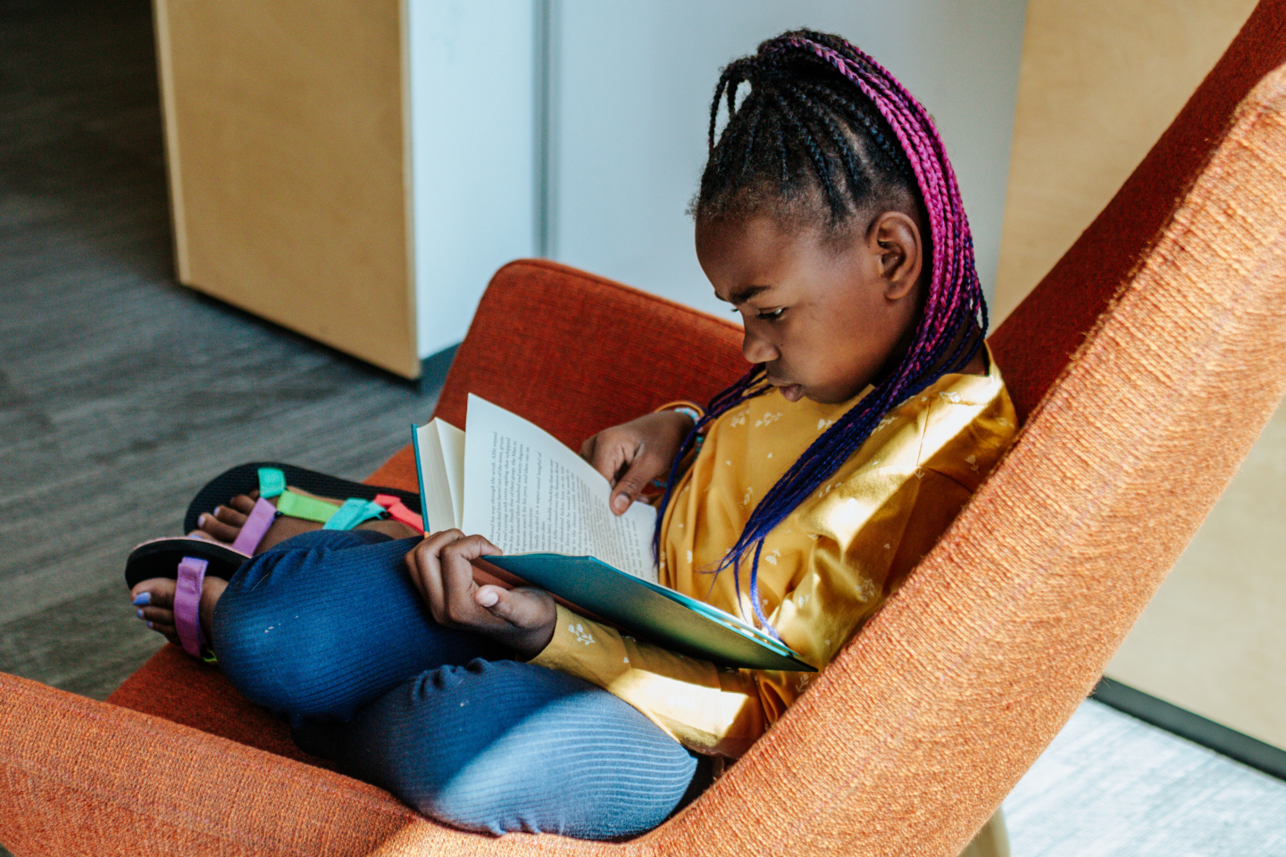 Young girl reading in a chair