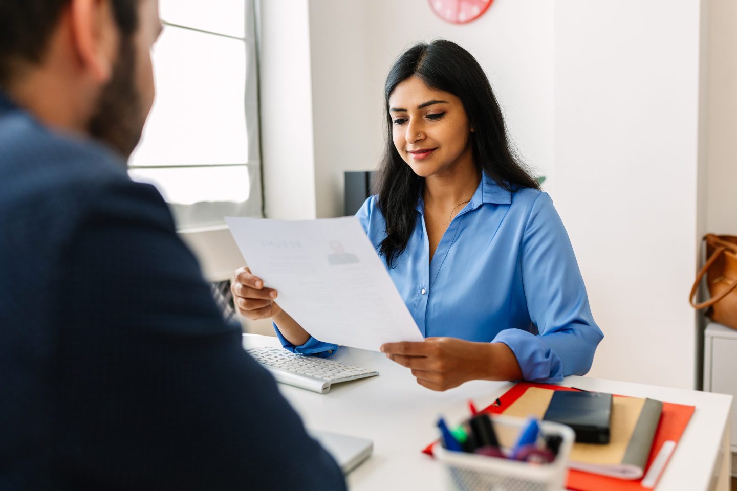 woman in blue button down looking at a piece of paper