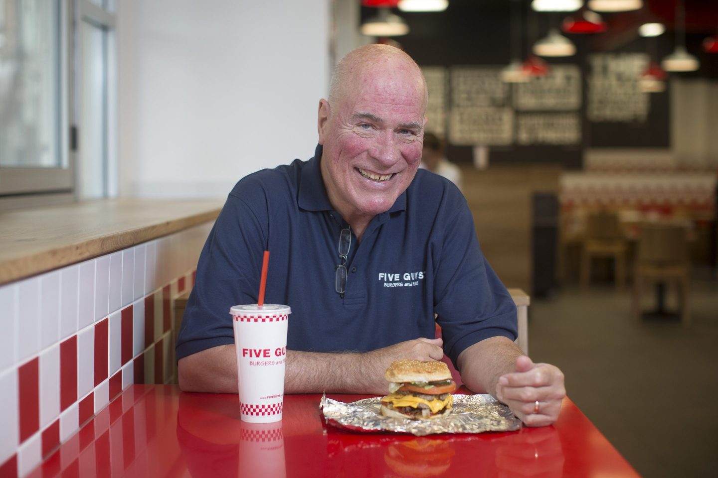 Jerry Murrell, founder of Five Guys, poses for a photograph inside the company's new hamburger outlet in London, U.K., on Tuesday, July 2, 2013. Five Guys, the U.S. burger restaurant chain which is set to open its first U.K. store in Covent Garden on July 4, is a family outfit that started in Washington, D.C., in 1986, and has expanded to more than 1,000 locations in the U.S. and Canada. Photographer: Simon Dawson/Bloomberg via Getty Images