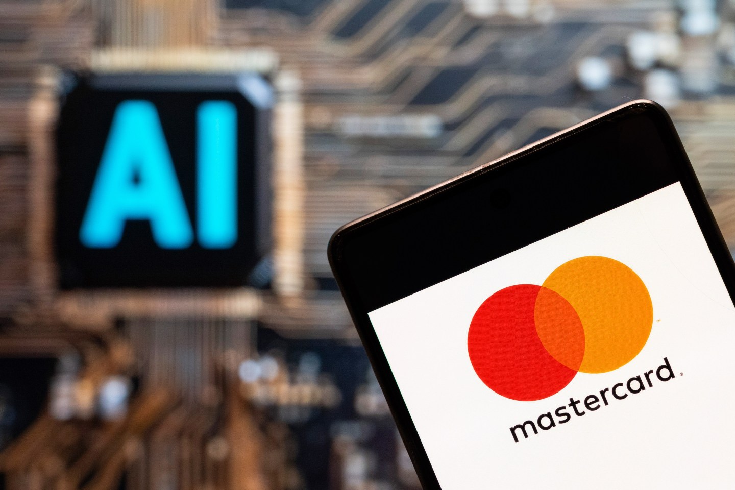 Mastercard logo seen displayed on a smartphone with an Artificial intelligence (AI) chip and symbol in the background.