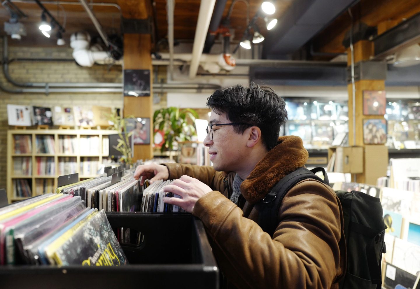 A young man browning through a records section at a music store
