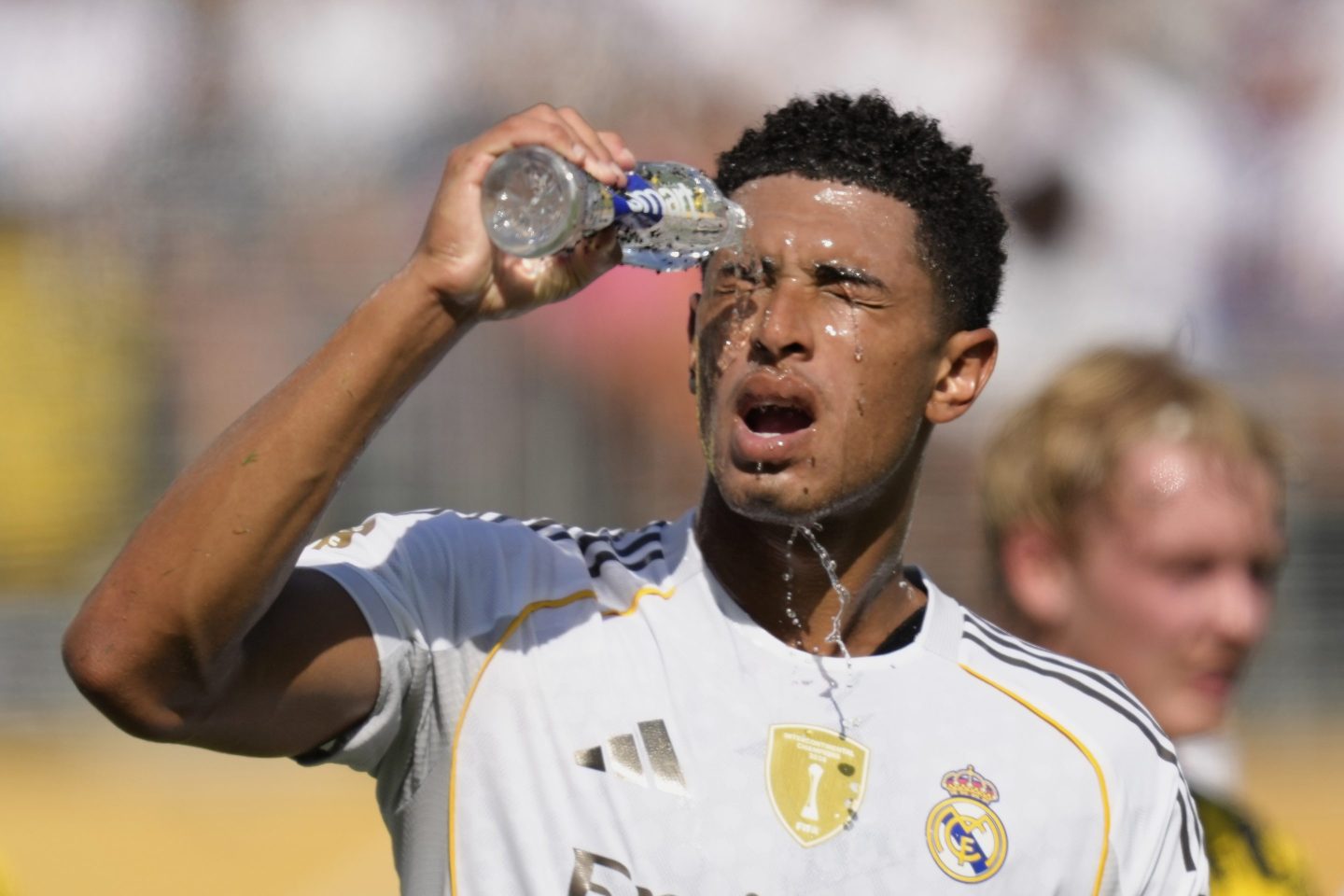 Real Madrid player Jude Bellingham pours water on his face during a break
