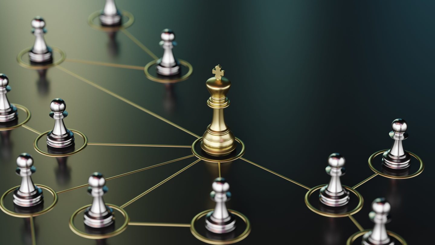 Image of a golden chess king connected to silver pawns, symbolizing teamwork, hierarchy, and leadership concepts in decision-making and strategy formation.