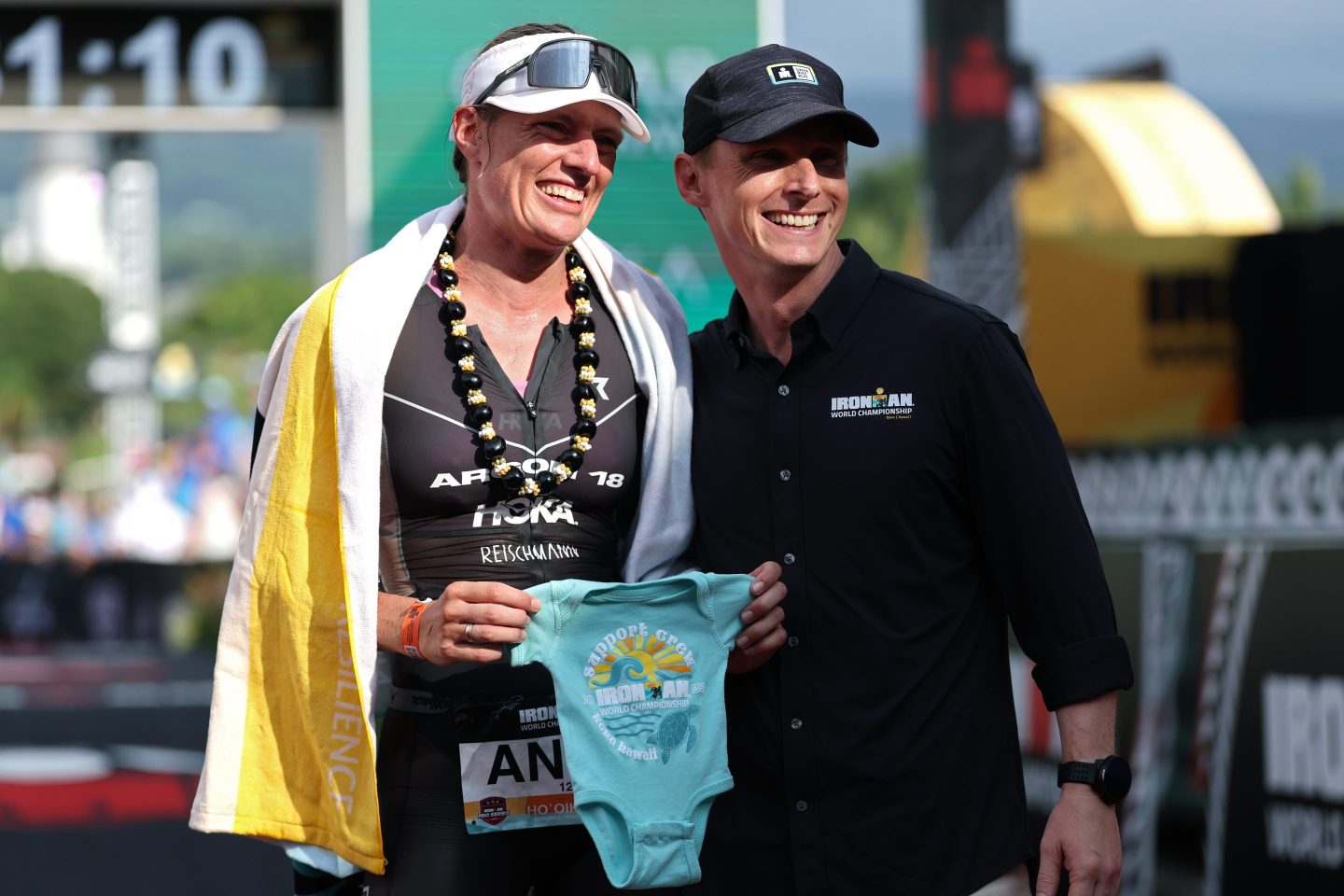KAILUA KONA, HAWAII - OCTOBER 11: Ironman CEO Scott DeRue and Anne Reischmann #12 of Germany pose for a  photograph after the 2025 IRONMAN World Championship Women's Race on October 11, 2025 in Kailua Kona, Hawaii. (Photo by Sean M. Haffey/Getty Images for IRONMAN)