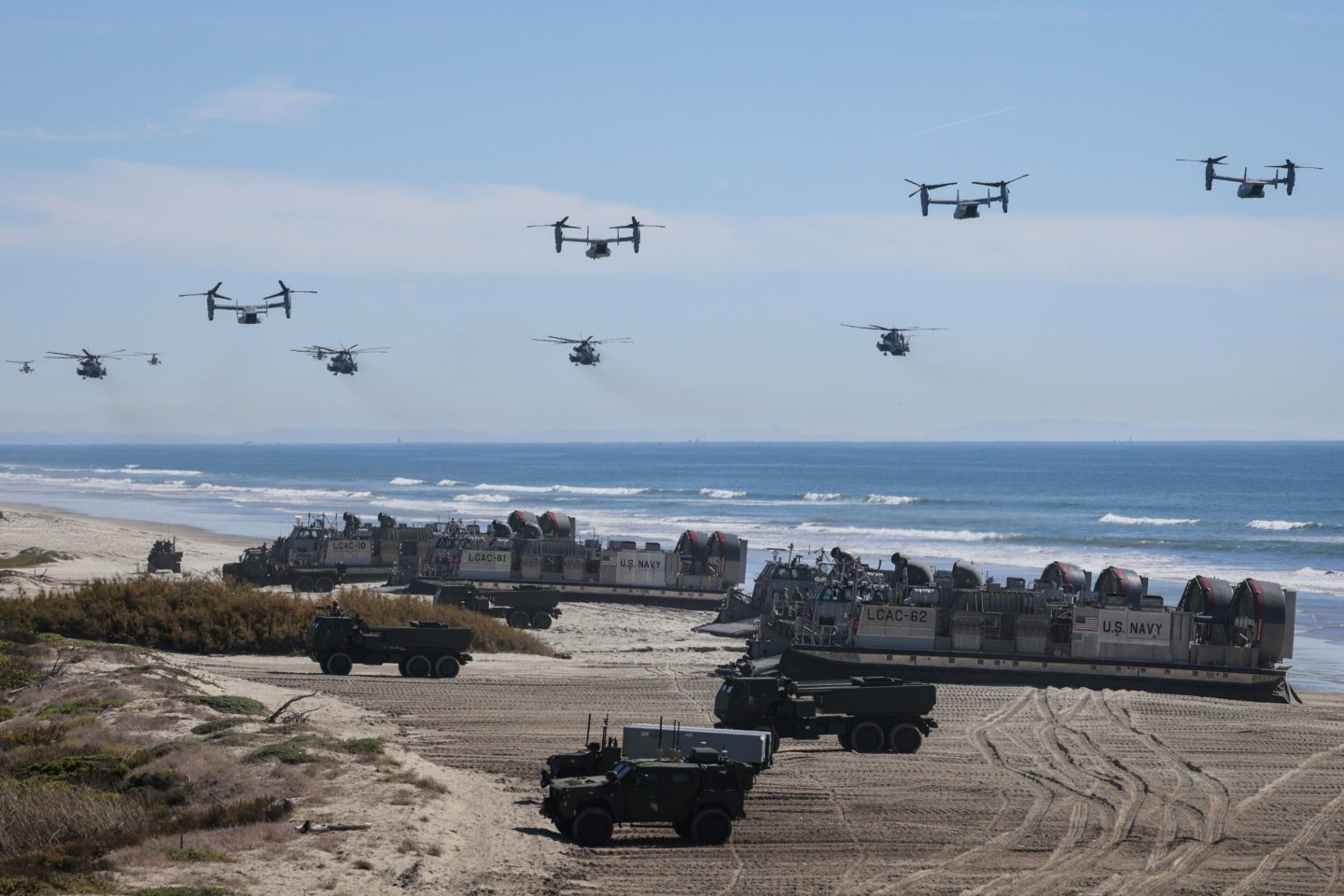 OCEANSIDE, CALIFORNIA - OCTOBER 18: U.S. Navy Landing Craft Air Cushion's (LCAC) unload equipment onto the beach as  U.S. Marine Corps V-22 Ospreys and CH-53 Super Stallions fly overhead during the America's Marines 250 event at Camp Pendleton's Red Beach on October 18, 2025 in Oceanside, California. The U.S. Marines are marking their 250th anniversary with a live amphibious assault demonstration entitled "Sea To Shore--A Review of Amphibious Strength" and visits from Vice President JD Vance and War Secretary Pete Hegseth. (Photo by Mario Tama/Getty Images)