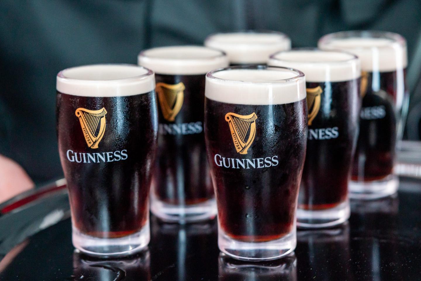 Several pints of Guinness lined up on a bar