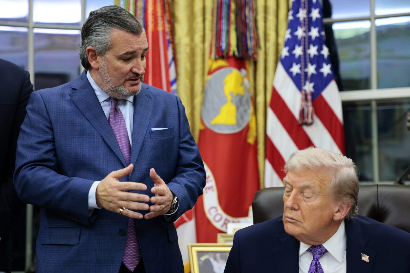 Ted Cruz stands and looks down at Donald Trump sitting at his desk in the Oval Office.