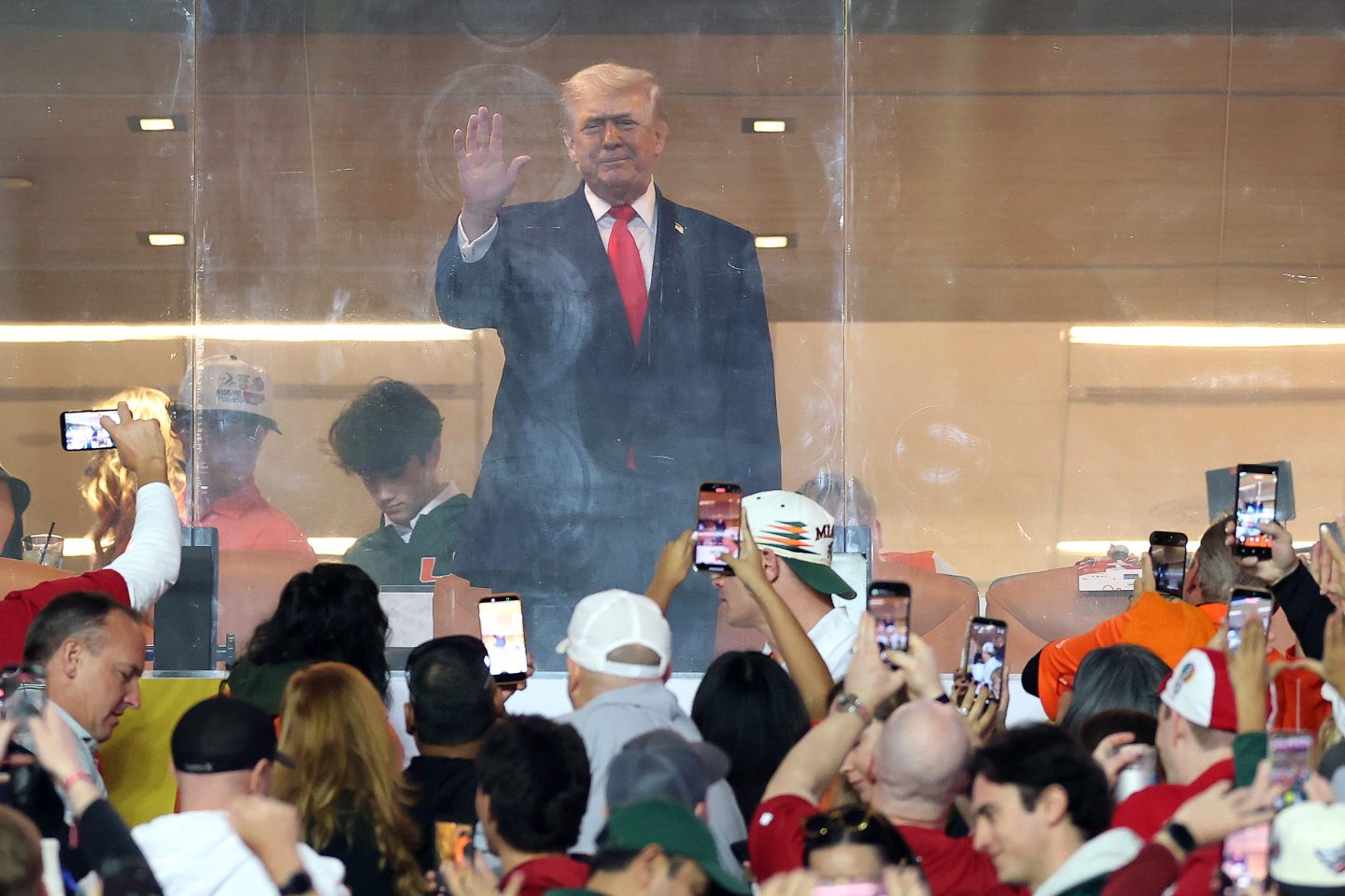 Trump standing waving hi at a crowd