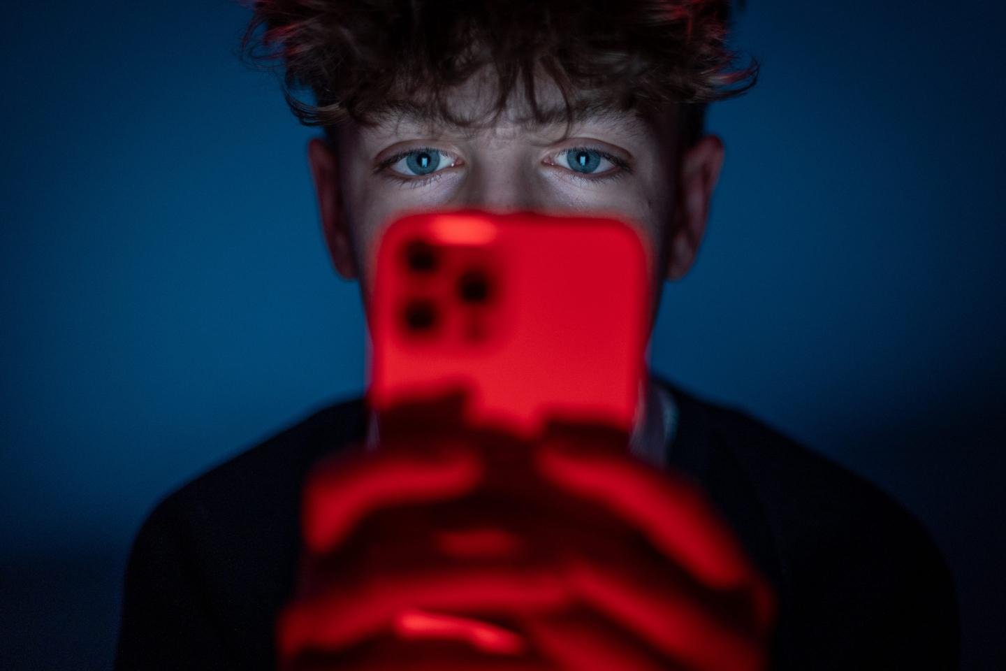 boy holding phone in front of his face