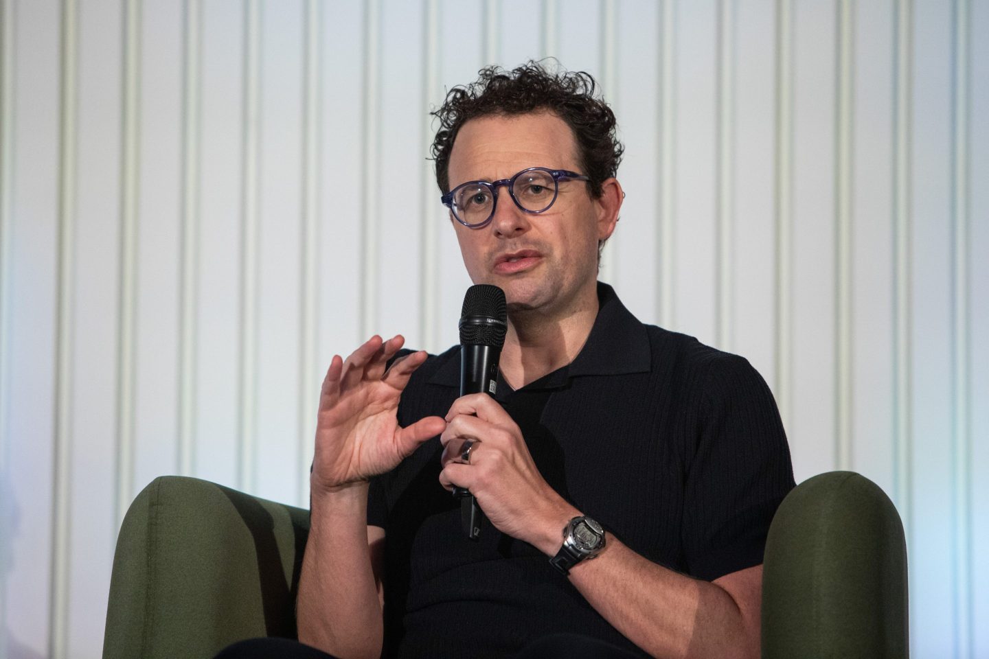 Anthropic CEO Dario Amodei speaking into a microphone.