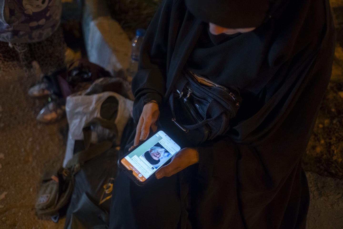 A veiled Iranian woman holds her cellphone displaying a portrait of Iran's Supreme Leader, Ayatollah Ali Khamenei,