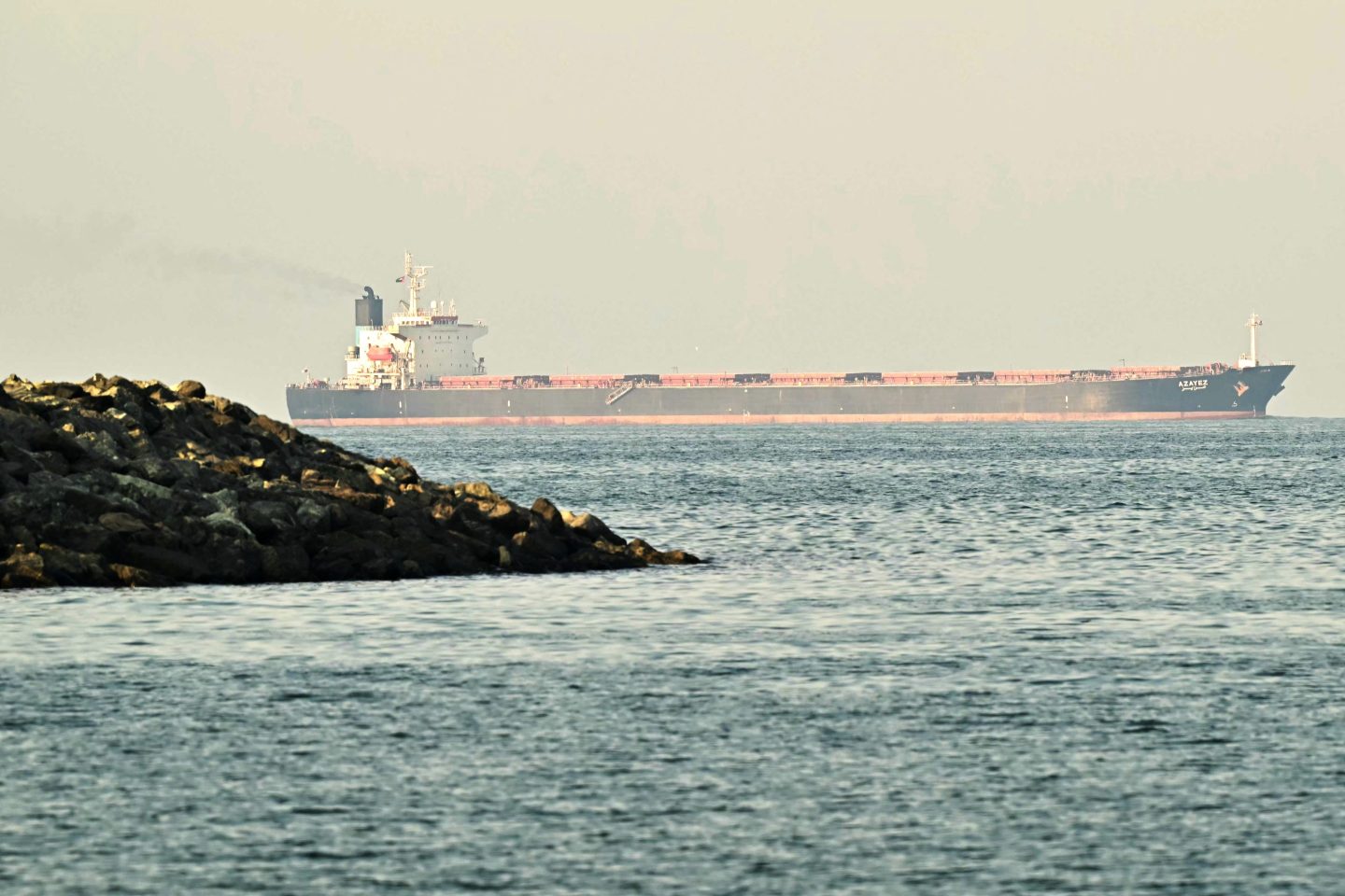 A cargo ship is pictured off coast city of Fujairah, in the Strait of Hormuz in the northern Emirate on February 25, 2026. (Photo by Giuseppe CACACE / AFP via Getty Images)