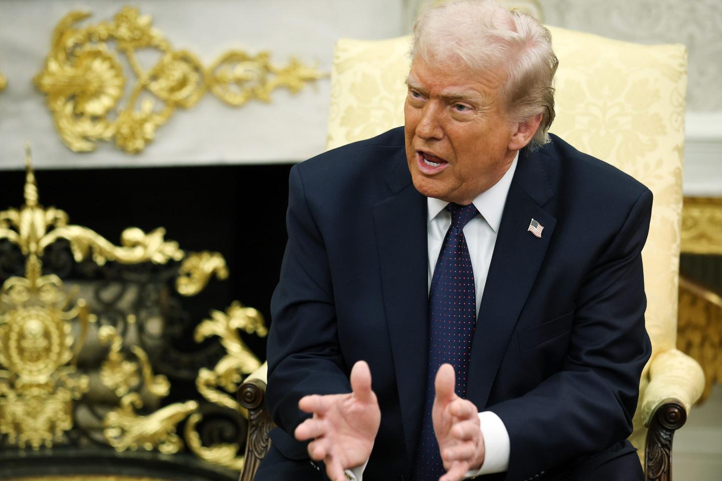 Trump sits and gestures.
