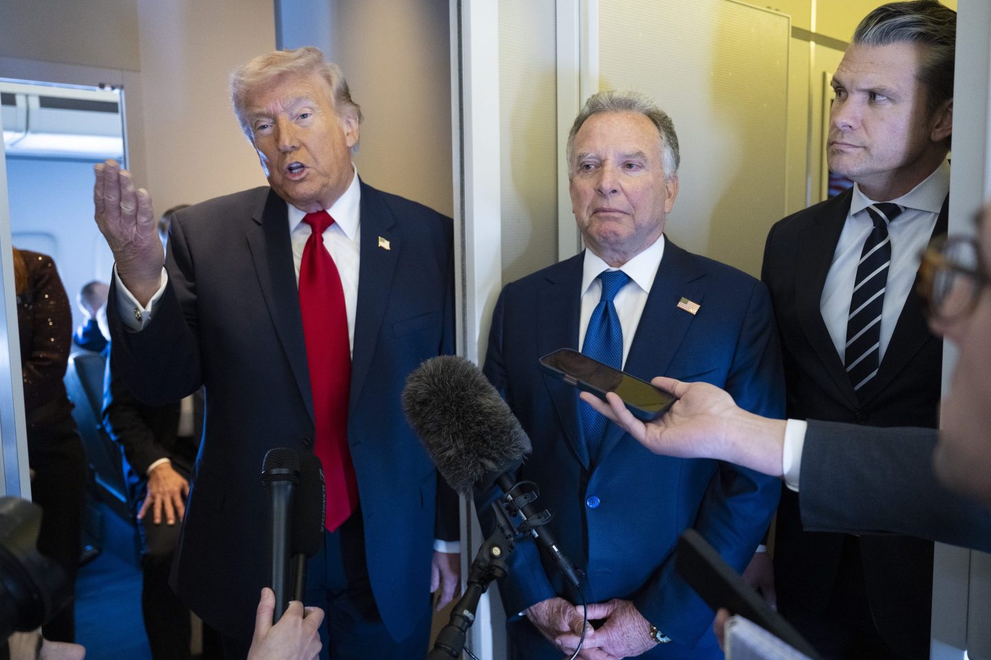 President Donald Trump speaks to members of the media traveling on Air Force One while heading to Miami on March 7, 2026 as United States Special Envoy to the Middle East Steve Witkoff and U.S. Secretary of War Pete Hegseth listen in. President Trump and other members of the government attended the dignified transfer of six soldiers from the 103rd Sustainment Command who were killed in action by an Iranian drone strike on March 1 in Port of Shuaiba, Kuwait during "Operation Epic Fury". (Photo by Roberto Schmidt/Getty Images)