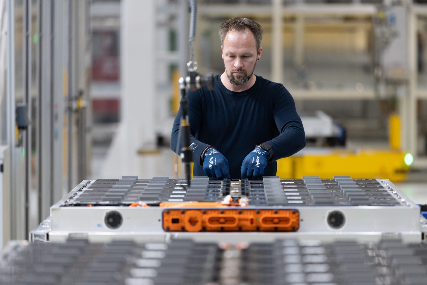 A technician in Germany works on a battery system for a Volkswagen electric vehicle.