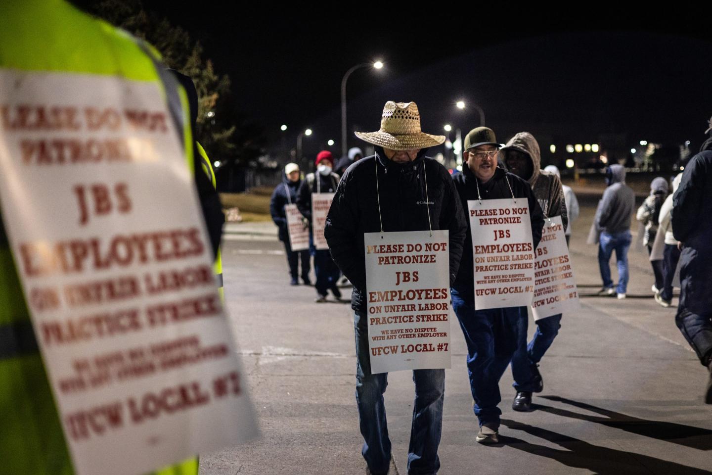 Strikers holding signs against JBS beef meatpacking