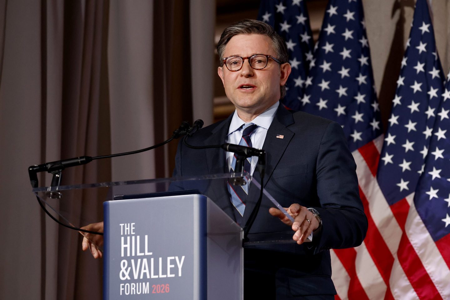 Mike Johnson stands a podium and speaks