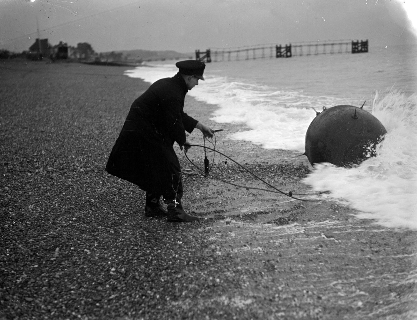 A bomb disposal officer in 1945 pulling a mine from the sea on the South East coast of Britain near Hythe.