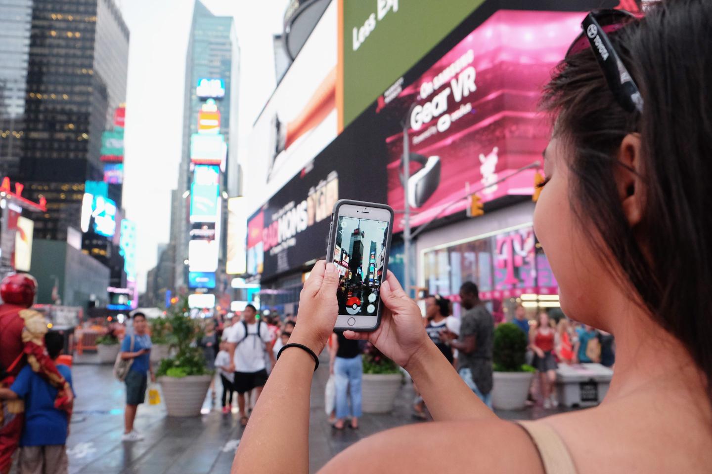woman holds phone in times square