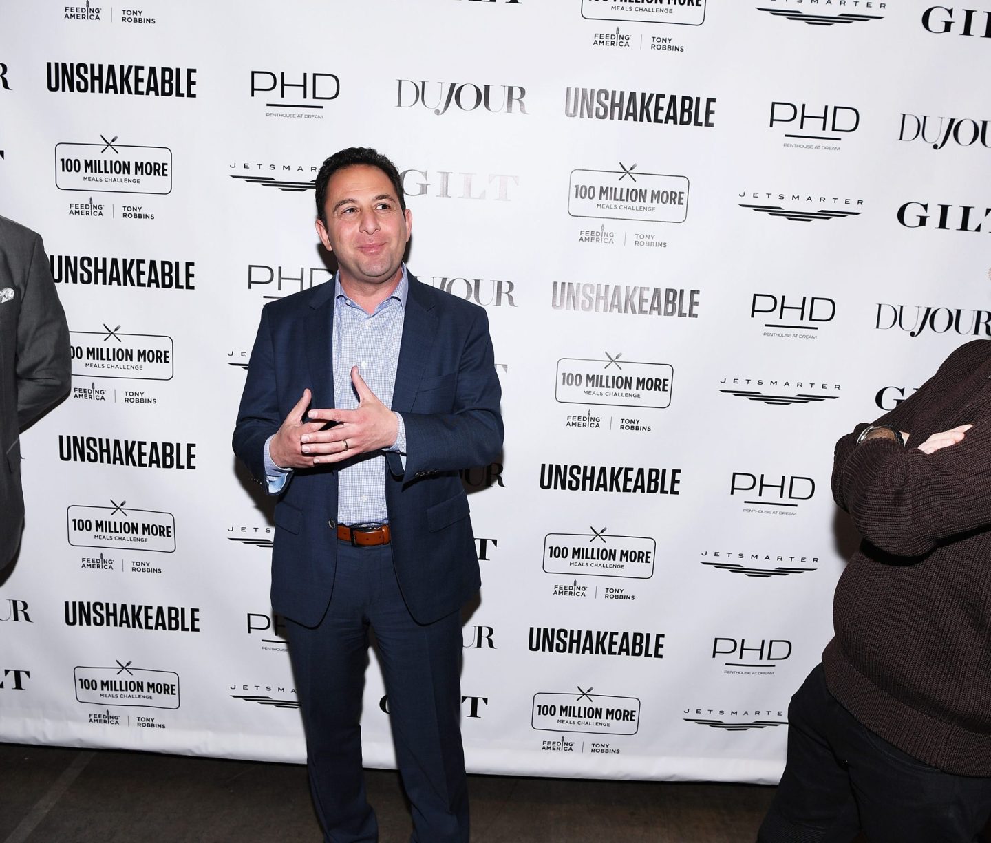 Three men standing in front of a white background.