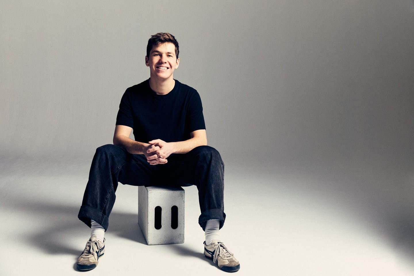 Tim Lupo sits on a stool and smiles