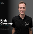 Rick Chorney, homme en polo noir sur fond gris foncé