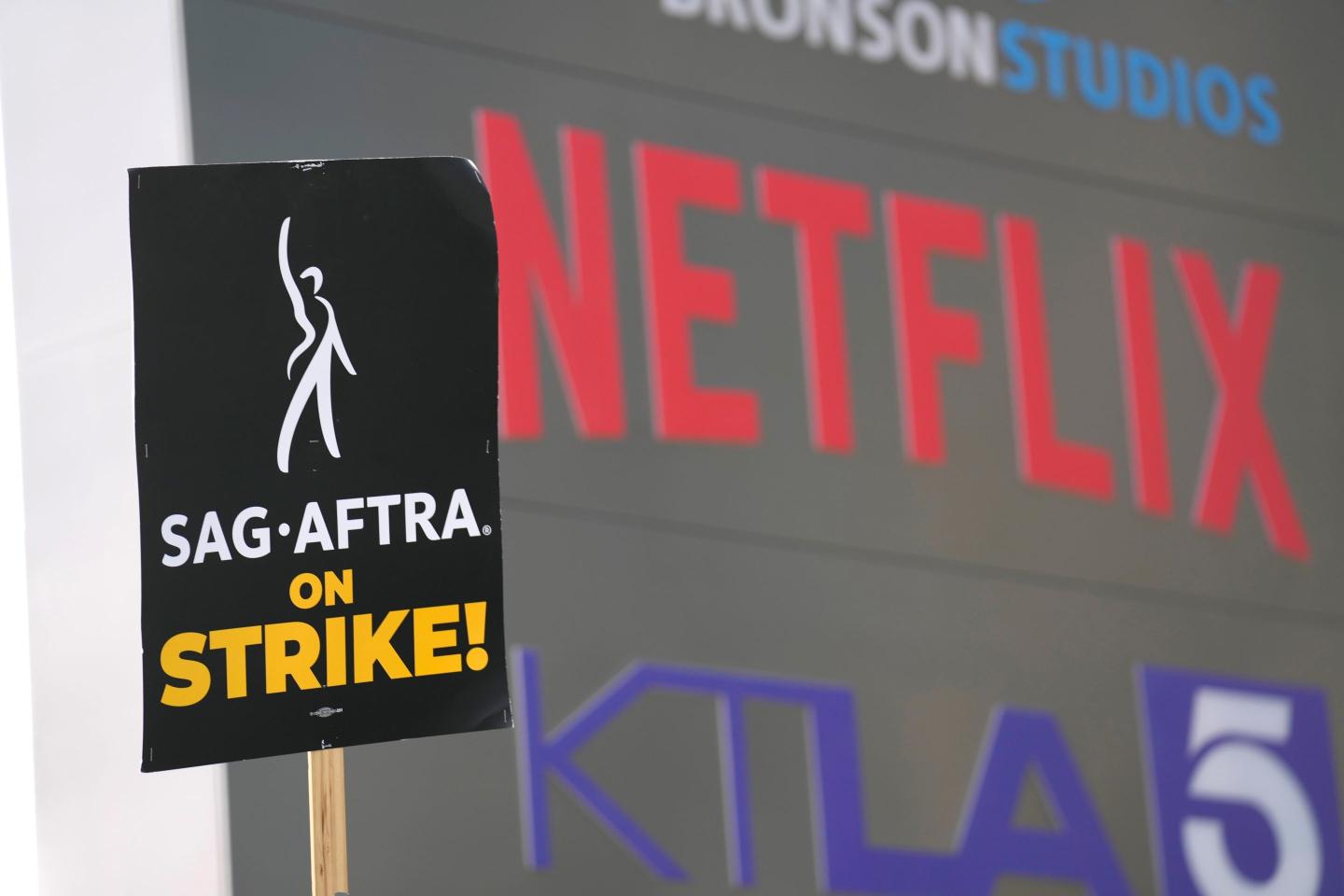 A picketer carries a sign on the picket line outside Netflix on Wednesday, Sept. 27, 2023, in Los Angeles.