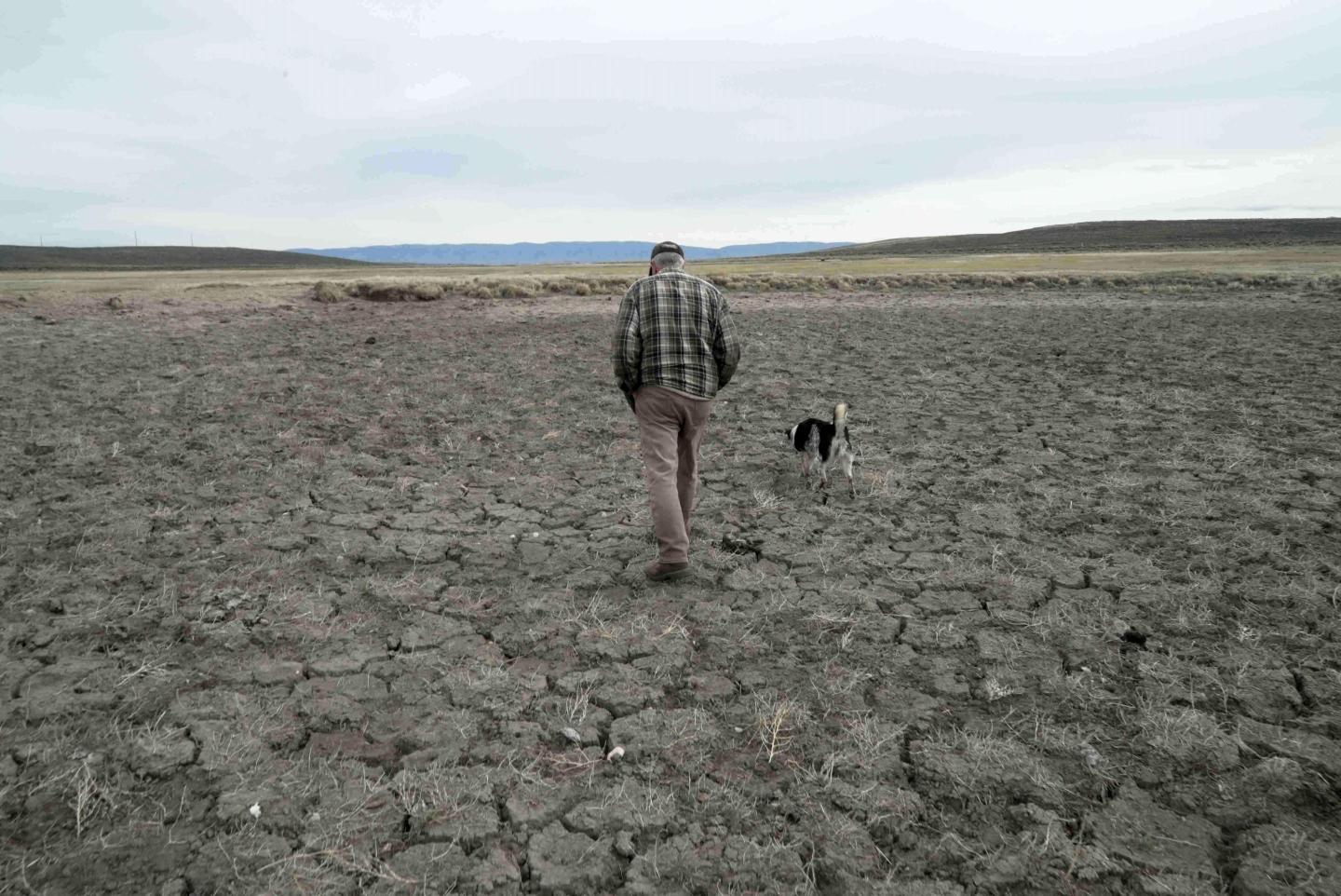 Philip Anderson walks across a dry stock pond March 31, 2026, in Walden, Colo. 