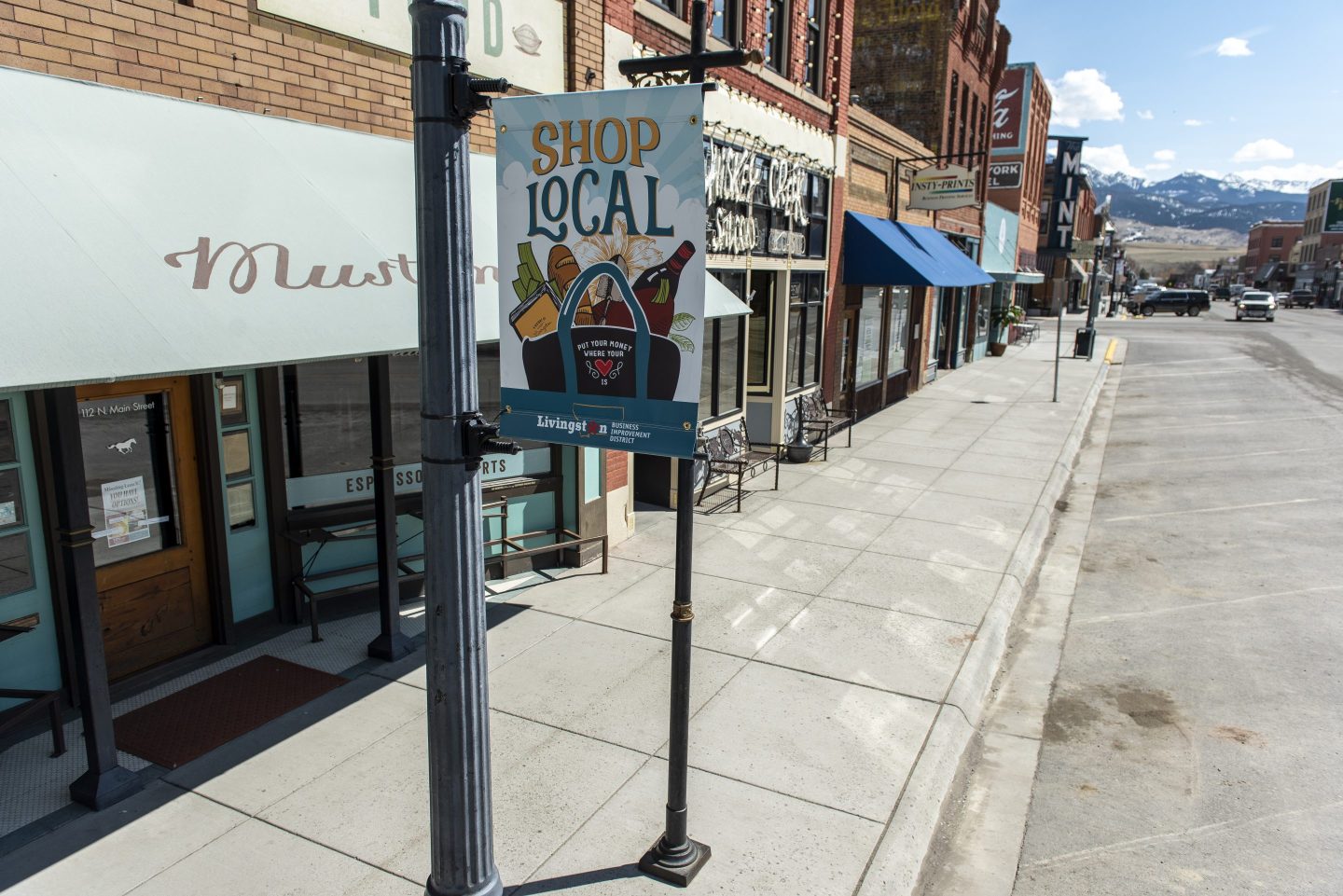 Empty storefront street with shop local sign