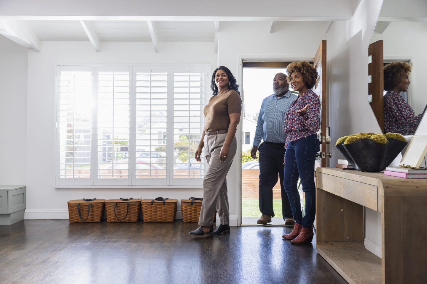 A couple being shown around a home by a realtor.