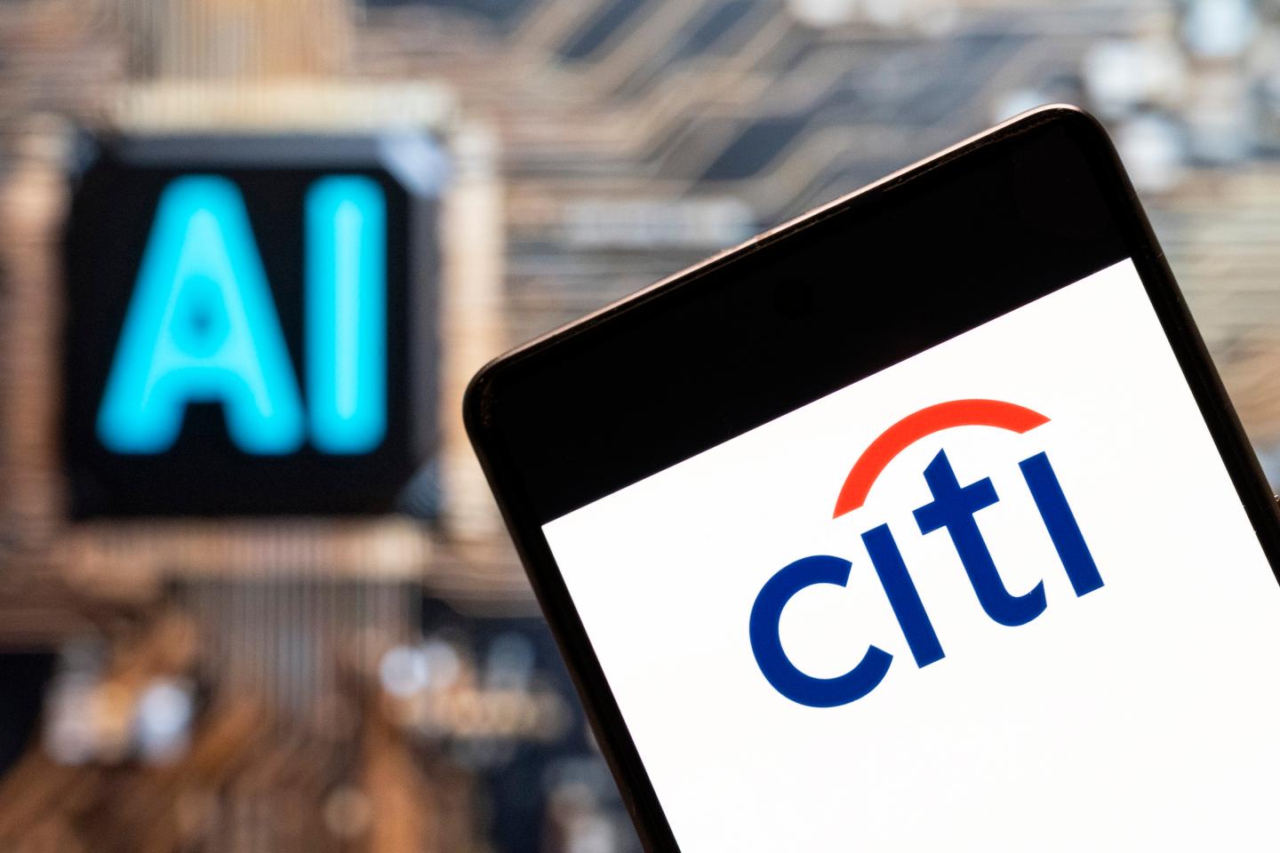 In this photo illustration, the American multinational investment bank, Citibank or Citi (NYSE: C), logo seen displayed on a smartphone with an Artificial intelligence (AI) chip and symbol in the background.