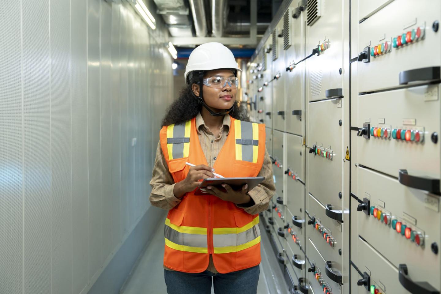 Industry engineer woman checking electrical operating system at a control room