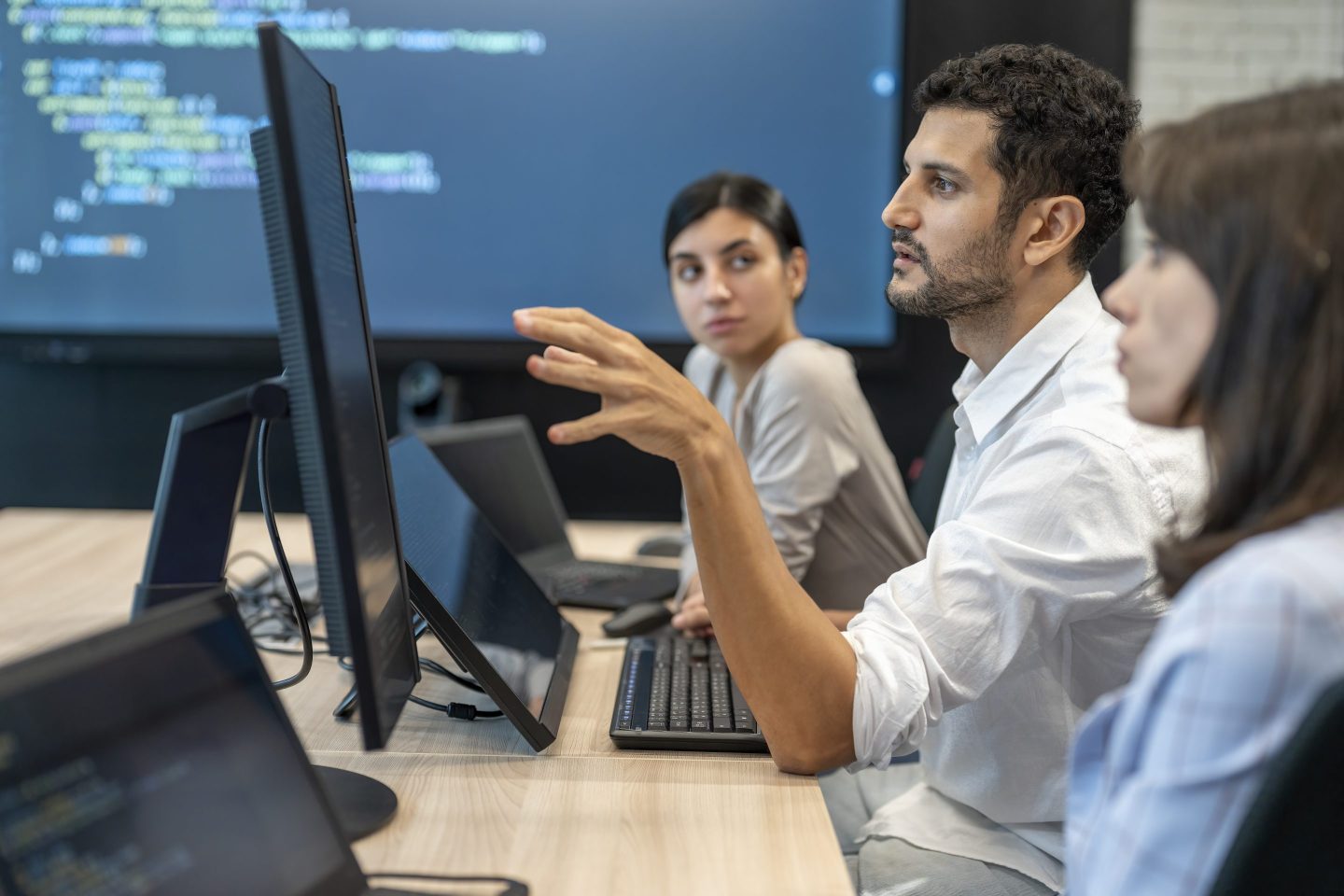 Software developers discussing programming code and planning how to create innovative software at co-working office. Two software developers checking programming code on computer screen. working through a coding problem together.