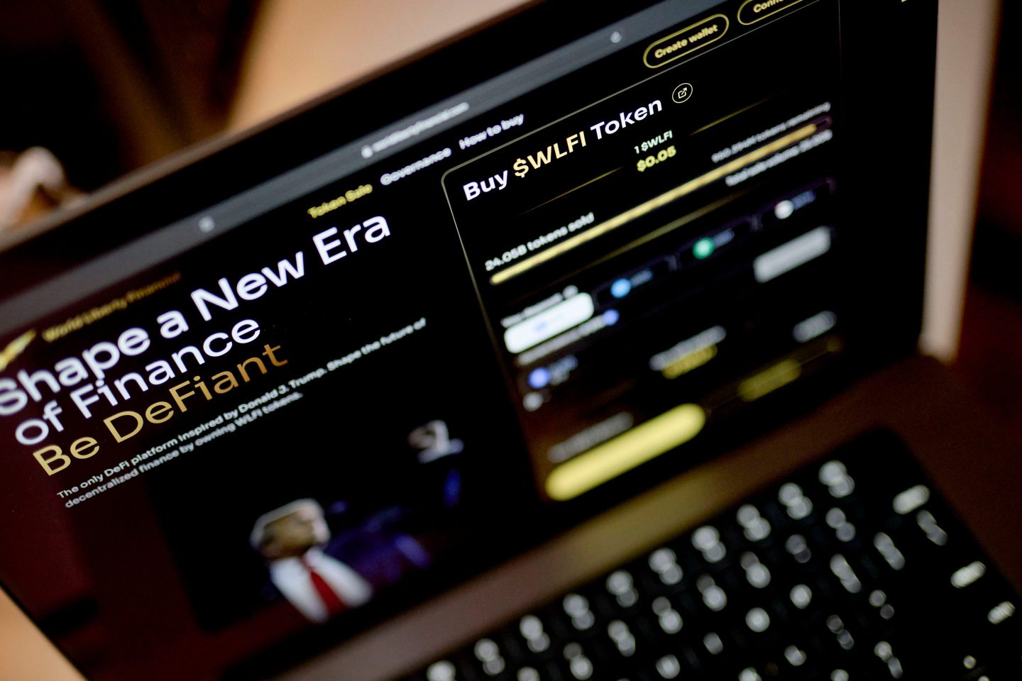 A laptop screen shows World Liberty Financial's website