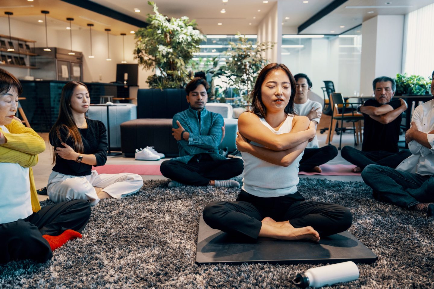 Business people doing relaxation exercises and yoga in an office.