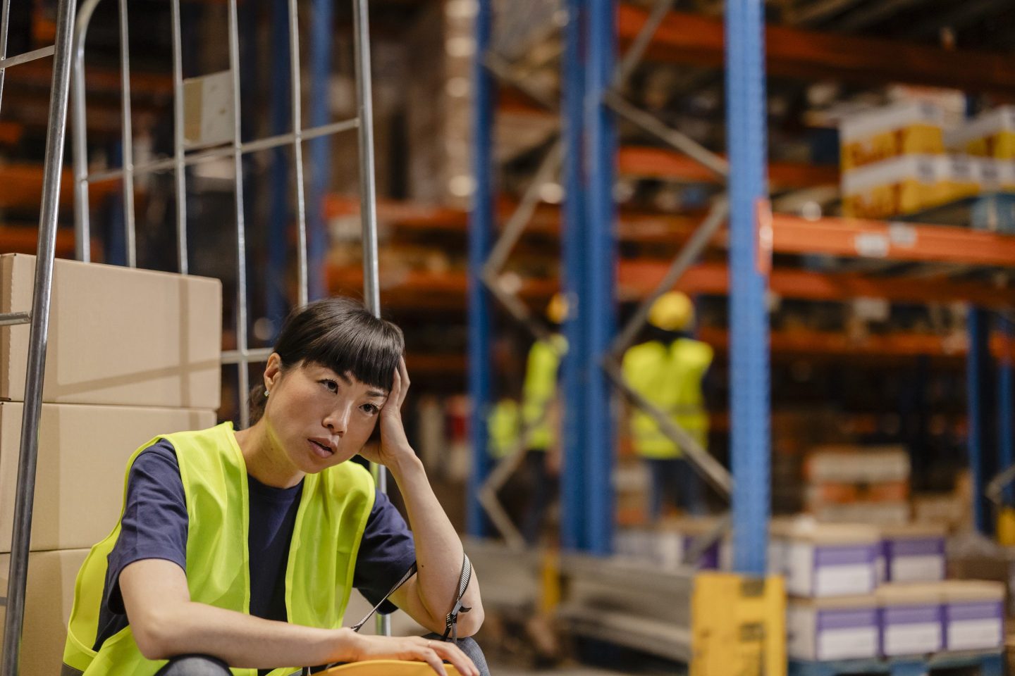 Sad woman working in warehouse
