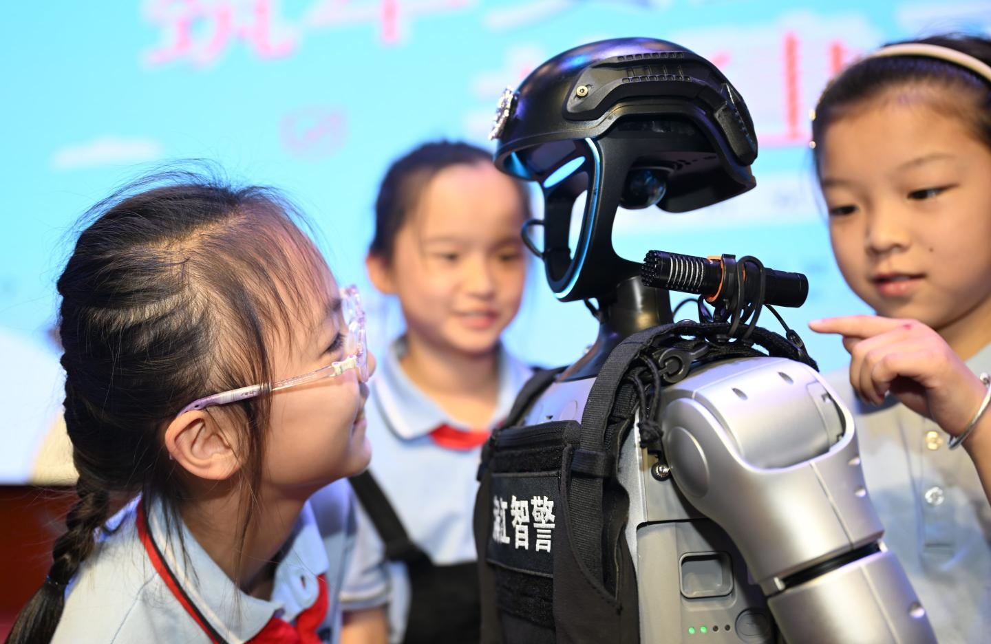 A group of young girls look at a robot.