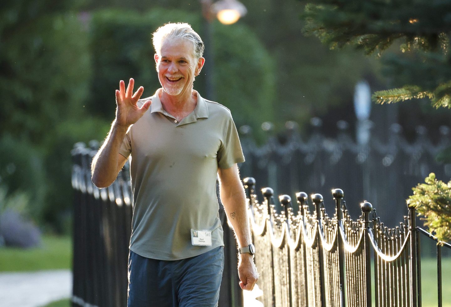 Man in t-shirt and jeans waving while walking