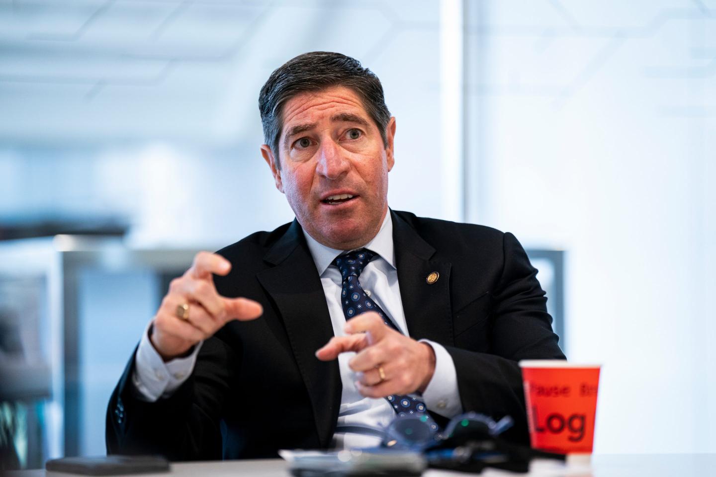 Scott Kupor sits at a table gesturing with both hands.
